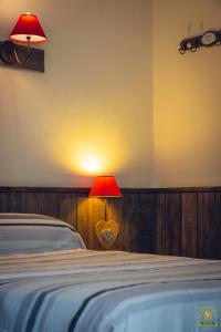 um quarto com uma cama com um candeeiro vermelho ao lado em The Liberty's em Villefranche-sur-Saône
