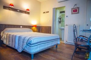 a bedroom with a bed and a table and a chair at The Liberty's in Villefranche-sur-Saône