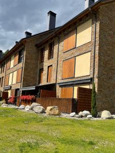 un grand bâtiment en briques avec des rochers devant lui dans l'établissement Santa María de Panticosa, à Panticosa