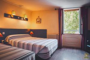 a bedroom with two beds and a window and a door at The Liberty's in Villefranche-sur-Saône