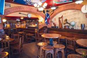 um bar com mesas e cadeiras de madeira num restaurante em The Liberty's em Villefranche-sur-Saône