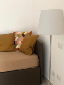 a lamp sitting next to a bed with pillows at NANNARE' APPARTAMENT in Reggio Emilia