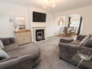 a living room with two couches and a fireplace at 28 Alwen Drive in Colwyn Bay