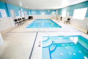 uma grande piscina num quarto com paredes azuis em Holiday Inn Express Hotel & Suites Carlsbad, an IHG Hotel em Carlsbad