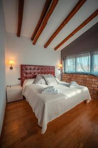 a bedroom with a large bed and a brick wall at Casa Aurelio Wellness Suite & Spa Inclusive in Taormina