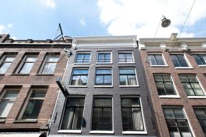 - un bâtiment en briques avec des fenêtres sur le côté dans l'établissement Hotel IX Nine Streets Amsterdam, à Amsterdam