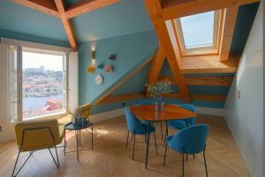 een eetkamer met een tafel en blauwe stoelen bij HM - Infante Riverside Apartment R in Porto