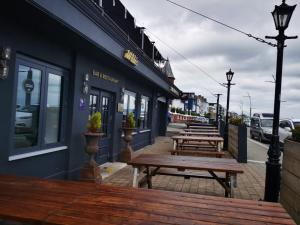 een rij banken buiten een gebouw bij The Strand Hotel former Home of Oscar Wilde & Caffe Vergnano 1882 in Bray