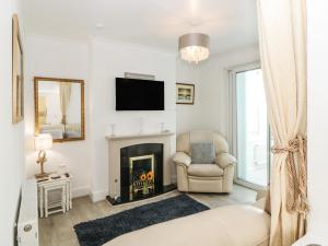 a living room with a fireplace and a tv at Pier View in Paignton