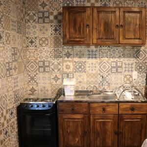 a kitchen with wooden cabinets and a stove and a sink at Casa Goethe - Bio Cult in Campo Alegre