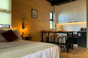 a bedroom with a bed and a kitchen with a counter at Anoka Apart Hotel Boutique in Frutillar