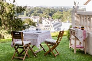 a table and chairs on the grass with a view at la source de bougival in Bougival