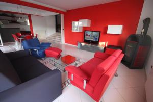 a living room with red walls and red chairs at Holiday house Veli vrh in Pula