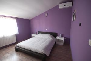 a purple bedroom with a bed and two tables at Holiday house Veli vrh in Pula +18 photos