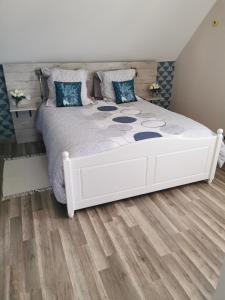 Schlafzimmer mit einem weißen Bett und Holzboden in der Unterkunft Bienvenue chez moi à Concevreux in Concevreux