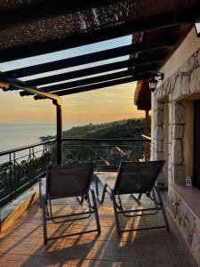 two chairs on a balcony with the ocean in the background at Villa Sunrise in Agia Paraskevi