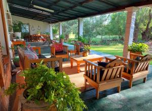 eine Terrasse mit Holzstühlen und einem Tisch in der Unterkunft Doornfontein Guest Farm in Cradock