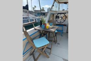 einen Tisch und Stühle auf einem Balkon auf einem Boot in der Unterkunft Beautiful 70s vintage yacht boat in Barcelona in Barcelona