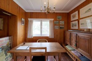 a dining room with a wooden table and a window at Vakantiewoning Zandhof in Oostduinkerke
