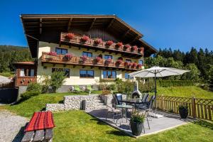 una casa con mesa, sillas y sombrilla en Haus Farmer en Sankt Martin am Tennengebirge