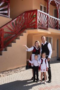 a family posing for a picture in front of a staircase at Pensiunea Fábián Vendégház in Corund
