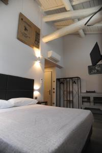 a bedroom with a white bed and a tv on the wall at TLcafè Hospitality (presso Torrefazione Lady Cafè srl) in San Secondo Parmense