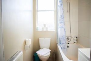 a bathroom with a toilet and a sink and a window at GuestReady - Calm and Central sleeps up to 6 in Edinburgh