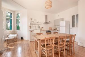 eine große Küche mit einem Holztisch und Stühlen in der Unterkunft A quelques pas de la plage coquet appartement pour un sejour a La Baule in La Baule