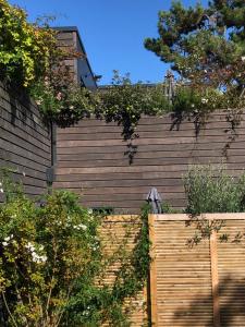 a wooden fence with plants on top of it at Cottages du Valcoquet in Saint-Brevin-les-Pins