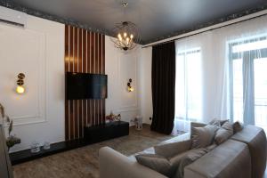 a living room with a couch and a flat screen tv at Villa Bonapart in Zatoka
