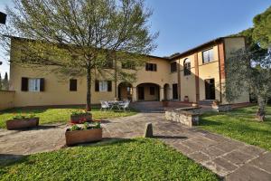 una vista exterior de una casa grande con patio en Fattoria Pagnana Suites & Pool, en Rignano sullʼArno