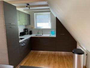 a kitchen with gray cabinets and a sink and a window at Terrasses de Malmedy Chalet l'undeuxtrois in Malmedy