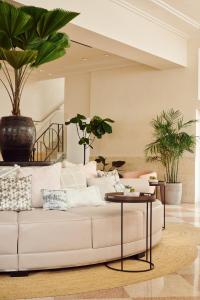 a white couch in a living room with plants at Hotel Greystone - Adults Only in Miami Beach