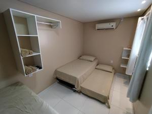 Cette petite chambre comprend 2 lits et une armoire. dans l'établissement Container LB com garagem para carros de até 4,5M, à Boa Vista