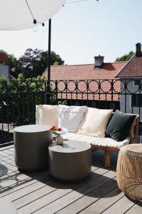 un sofá y mesas en una terraza con sombrilla en Kalk Hotel, en Visby