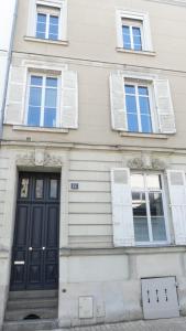 un edificio con una puerta negra y tres ventanas en Les Suites Angevines, en Angers