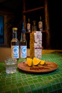 a table with two bottles of alcohol and a stack of playing cards at Casa Losodeli & Coworking- Adults Only in Puerto Escondido
