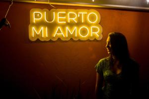 a woman standing in front of a neon sign at Casa Losodeli & Coworking- Adults Only in Puerto Escondido