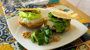 a sandwich on a plate on a table at Casa Losodeli & Coworking- Adults Only in Puerto Escondido