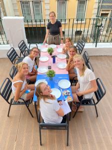 un grupo de mujeres sentadas alrededor de una mesa en Safestay Lisbon Bairro Alto en Lisboa