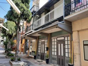 カヴァラにあるCITY CENTER VILLAの通りに面したバルコニー付きの建物