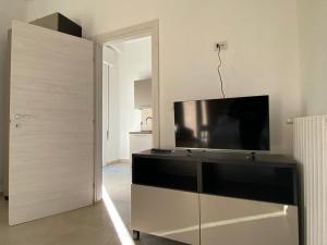 a living room with a flat screen tv on a cabinet at DaRò Apartments in Bologna