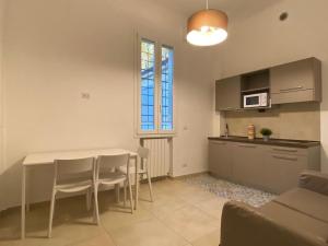 a kitchen with a table and chairs in a room at DaRò Apartments in Bologna