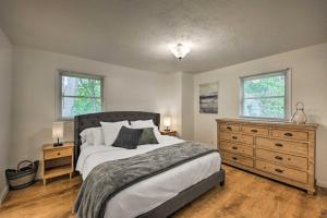 a bedroom with a bed and a dresser and two windows at Home - 2 Blocks to Lake Nagawicka Boat Launch in Delafield