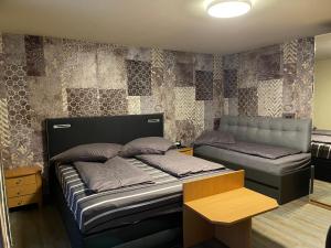 ein Schlafzimmer mit einem Bett und einer Bank darin in der Unterkunft Hotel Mythos "Apartments" in Markgröningen