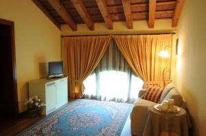 a living room with a couch and a tv at Relais Ca' Serena in Roncade