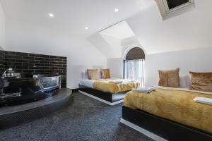 um quarto com 2 camas e uma lareira em Mixies Manor Sasco Apartments em Blackpool