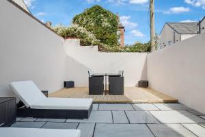 a patio with a white fence and a table and chairs at Mixies Manor Sasco Apartments in Blackpool