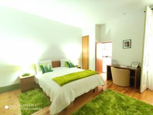 a bedroom with a large bed with a green blanket at Modern Apartment in Guimarães, 50 m², Balcony in Guimarães