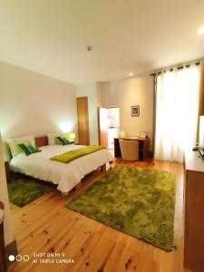 a bedroom with a large bed with a green rug at Modern Apartment in Guimarães, 50 m², Balcony in Guimarães